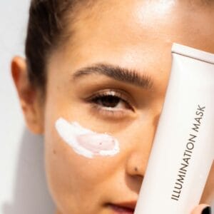 young woman applying skincare product to her face